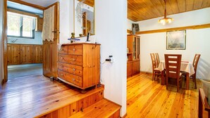 A wooden interior with a dining area, wooden cabinets, and a staircase.