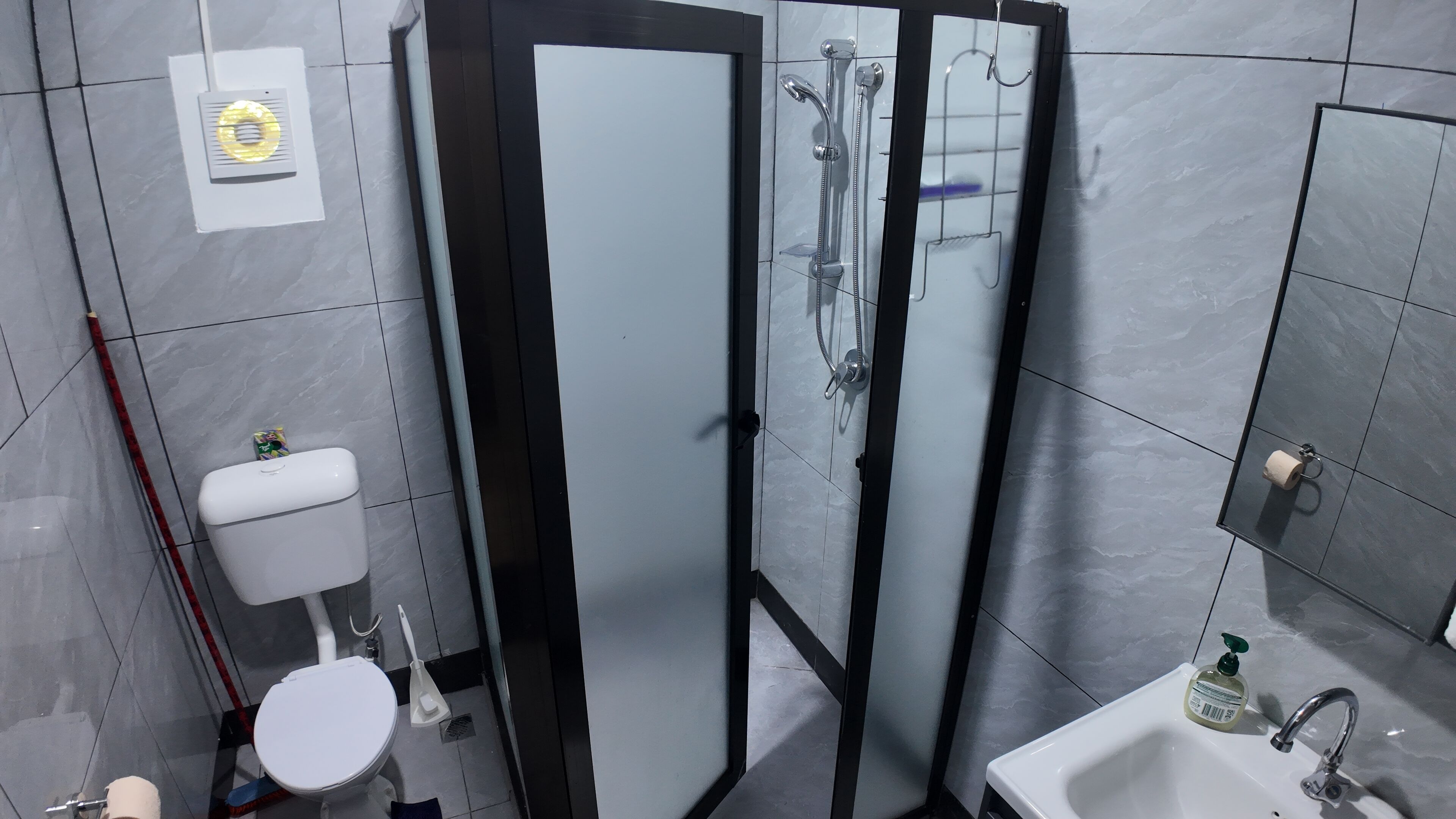 Een douche, handdoeken, zeep, toiletpapier