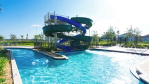 En swimmingpool med en vattenrutschkana och uppblåsbara badringar.