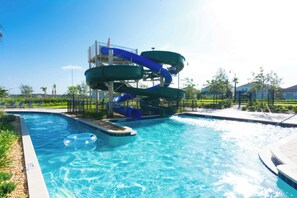 A swimming pool with a water slide and inflatable rings. - Enchanting 4BR Villa / Family Vacation Home Near Disney (Kissimmee)
