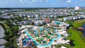 A resort with a large pool area, water slides, and a view of surrounding residential buildings. - Enchanting 4BR Villa / Family Vacation Home Near Disney (Kissimmee)