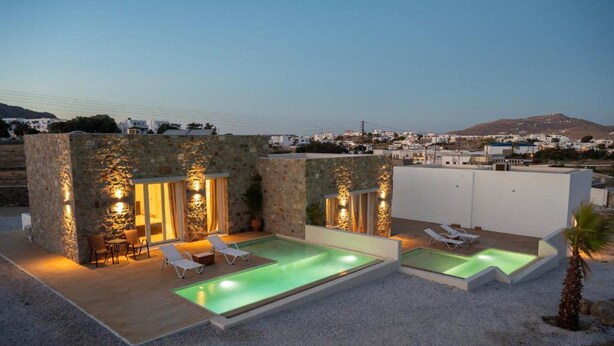 A modern villa with a pool, stone walls, and outdoor seating. - Adyton Luxury Suite Mykonos Exclusive Pool Oasis (Mykonos)