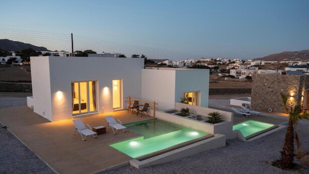 A modern villa with a swimming pool, outdoor seating, and a view of the surrounding landscape. - Adyton Luxury Suites Mykonos Private Pool Getaway (Mykonos)