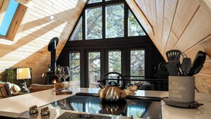 Una cocina moderna con un amplio ventanal, una tetera y un organizador de utensilios de cocina.
