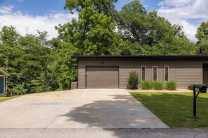 Une maison moderne à deux étages, dotée d’un garage, d’une pelouse bien entretenue et d’une boîte aux lettres.