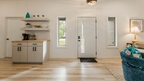 Une cuisine moderne dotée d’un plan de travail en bois, de meubles encastrés et d’un luminaire suspendu.