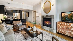 Una sala de estar moderna con chimenea, un sofá, una mesa de centro y un televisor.