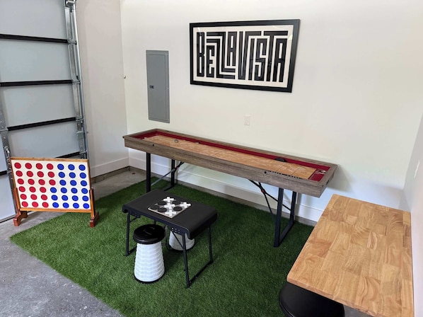 Ein Billardtisch mit roter Tischdecke, ein Snookertisch mit schwarz-weißer Bespannung und ein Dartboard mit roten und blauen Punkten.