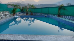 A swimming pool with a view of mountains in the background.