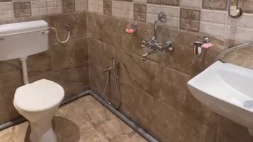 A bathroom with a toilet, sink, and shower.