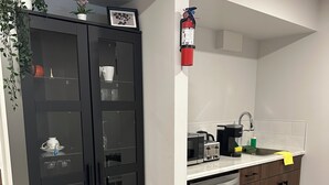 Uma cozinha moderna com um armário preto, uma lava-louças e um micro-ondas.