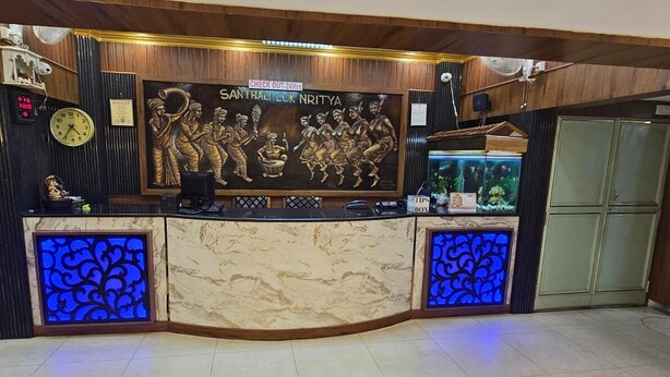 Un mostrador de recepción con un reloj, una mesa de salida y un acuario.