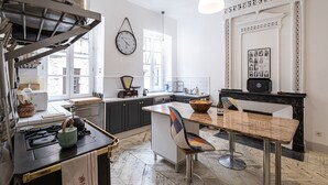 A modern kitchen with a central island, a dining area with a bar stool, and a fireplace.
