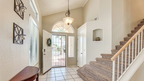 A hallway with a wooden table, a staircase, and a door leading outside. - Swim w/ a View: Scenic Desert Retreat in Glendale (Glendale)
