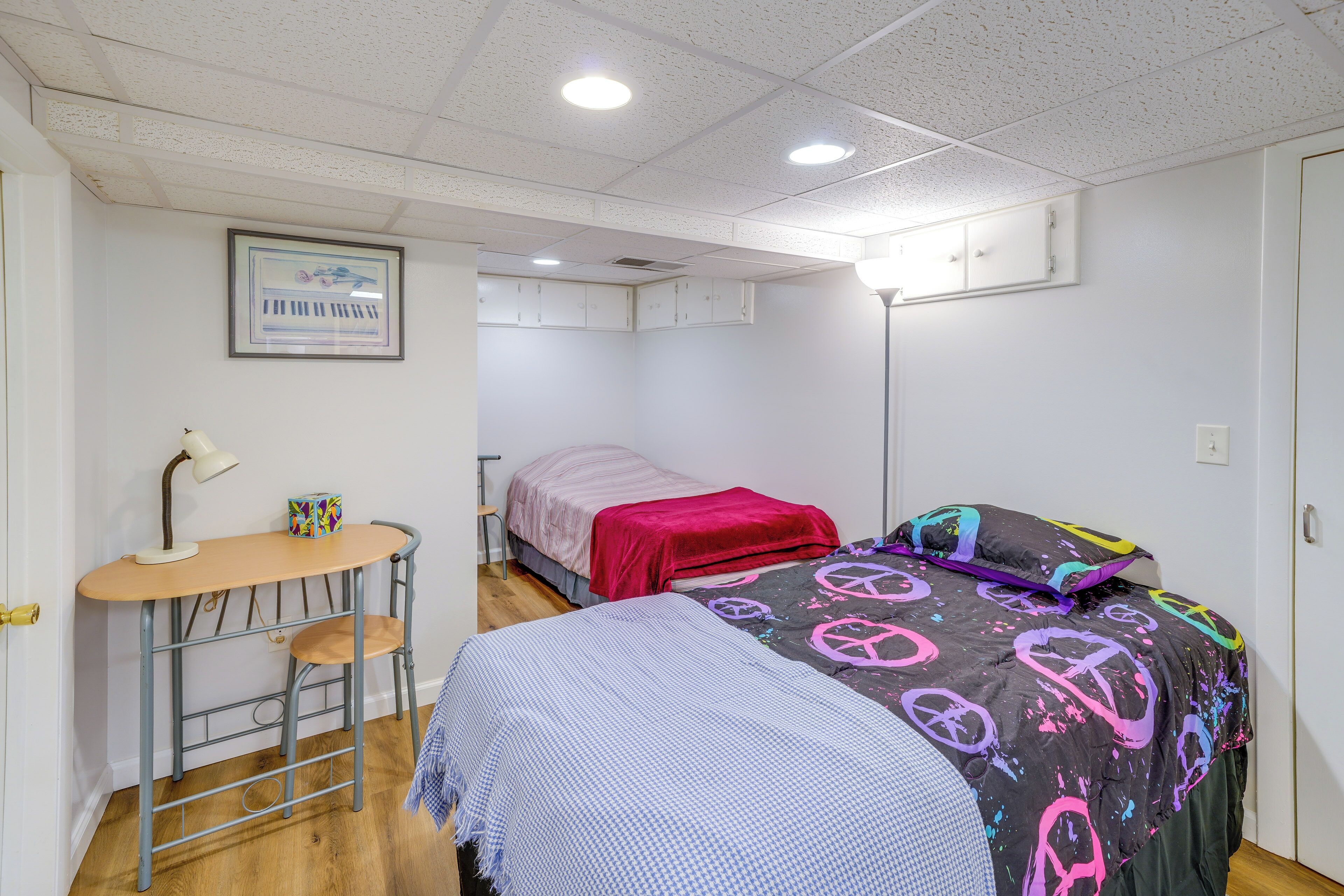 A room with two beds, a desk, and a chair.