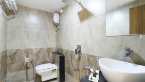 A bathroom with a toilet, bidet, shower, and sink. - Hotel Rose Gold (Vadodara)