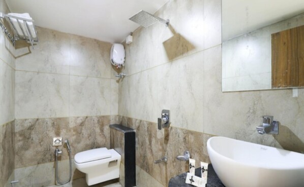 Un baño con inodoro, bidé, ducha y lavamanos.