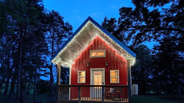 A red cabin with a porch, surrounded by trees. - Peace & Simplicity in a Little Red Cabin on the Farm (Lena)
