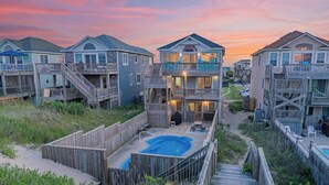 Una propiedad frente al mar con varias casas, una piscina y pasarelas de madera.