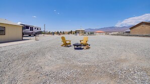 A gravel parking area with two yellow Adirondack chairs and a small table. - 6 Mi to Downtown Pahrump: Scenic Desert Retreat (Pahrump)