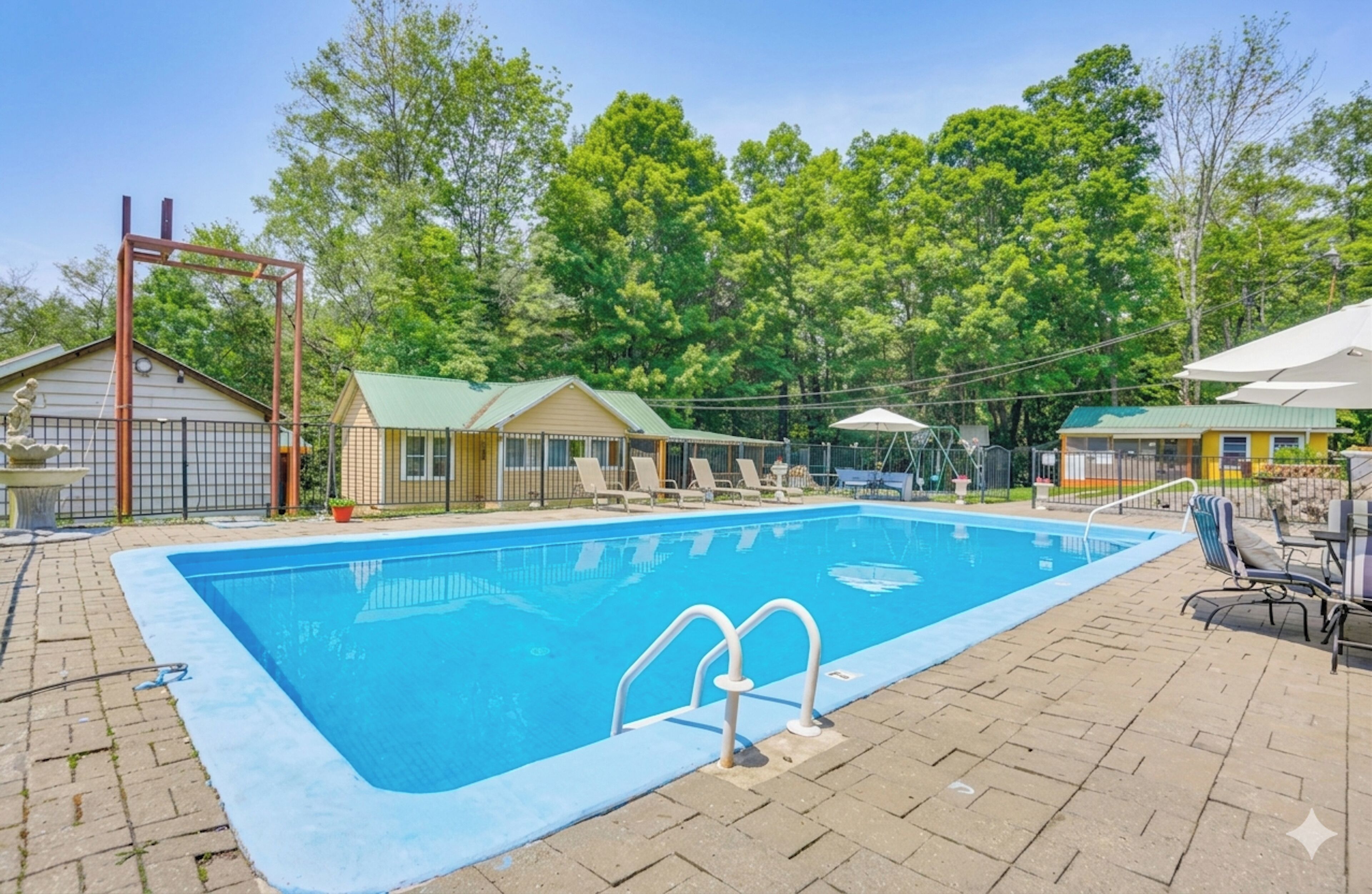 A rectangular swimming pool with a metal ladder, surrounded by a brick patio.