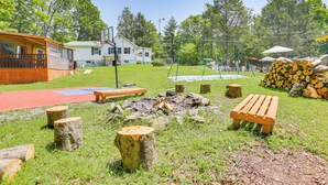 A backyard with a wooden bench, a fire pit, and a basketball hoop. - 5 Mi to Marina & Raceways: Monticello Retreat! (Mongaup Valley)