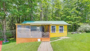 A small yellow cabin with a green roof, a porch, and a pathway leading to it. - 5 Mi to Marina & Raceways: Monticello Retreat! (Mongaup Valley)