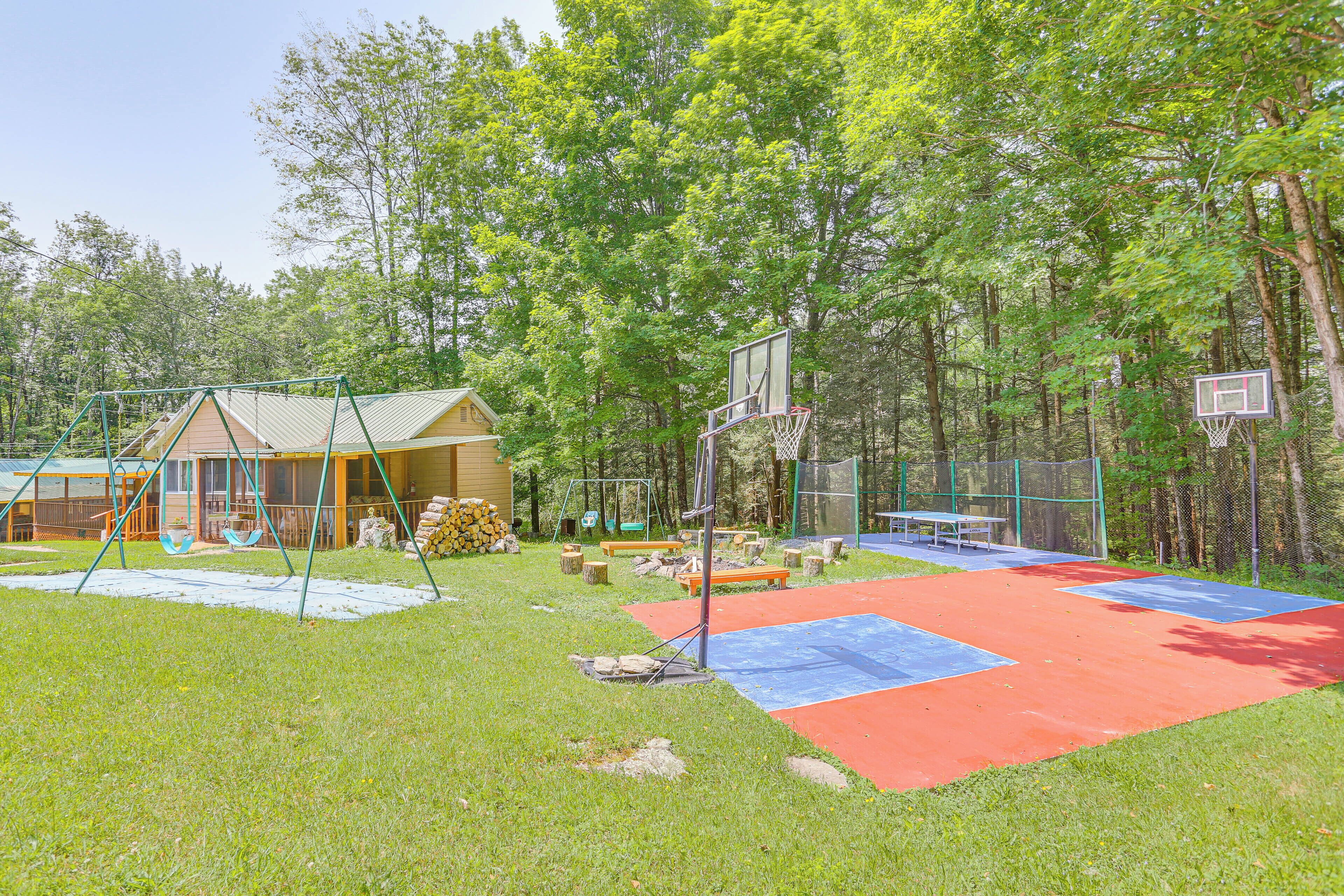 A playground with a swing set, a basketball hoop, and a red and blue play area.