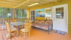 A covered outdoor area with a table and chairs, a sofa, and a door with a window. - 5 Mi to Marina & Raceways: Monticello Retreat! (Mongaup Valley)