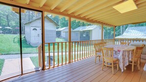 A covered patio with a table and chairs, a wooden railing, and a view of neighboring houses. - 6 Mi to State Park: Monticello Cabin! (Mongaup Valley)