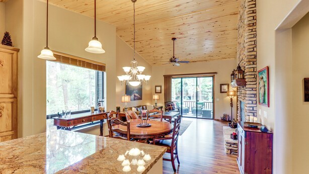 A spacious kitchen with a large island, wooden ceiling, and a dining area with a stone accent wall. - 4 Miles to Lake: Retreat w/ 2 Decks! (Show Low)