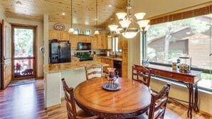 A wooden kitchen with a dining table, chairs, and a chandelier. - 4 Miles to Lake: Retreat w/ 2 Decks! (Show Low)