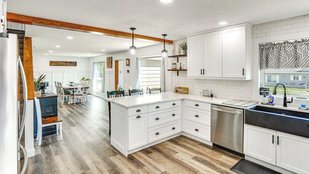 A modern kitchen with white cabinetry, a stainless steel dishwasher, and a large island with drawers. - 15 Mi to Downtown Sioux Falls: Gem w/ Yard! (Hartford)
