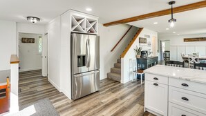 A modern kitchen with a stainless steel refrigerator, white cabinetry, and a marble countertop. - 15 Mi to Downtown Sioux Falls: Gem w/ Yard! (Hartford)