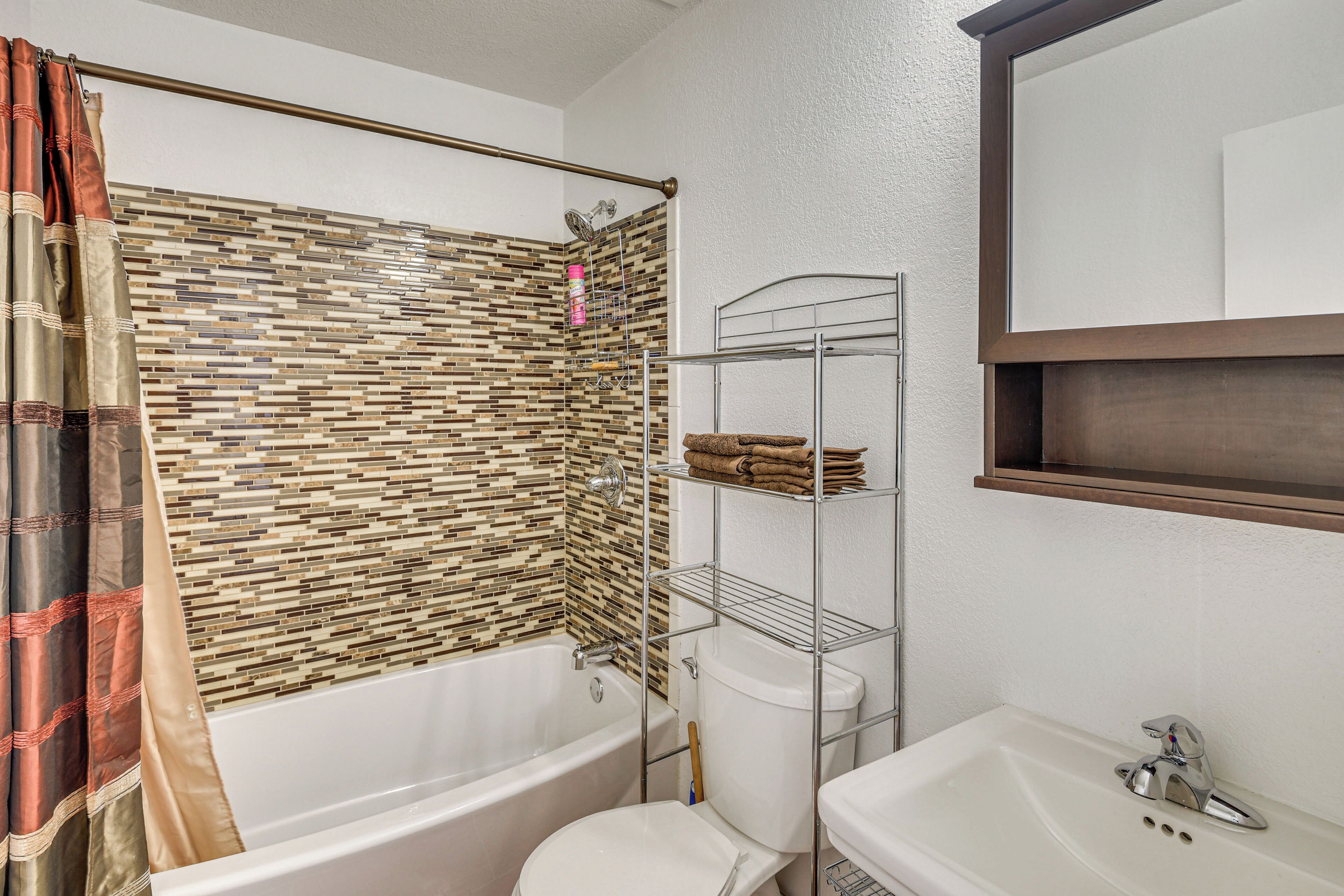 Un baño con bañera, inodoro y lavamanos.