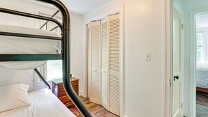 A bunk bed with white bedding, a wooden dresser, and a set of louvered closets. - Near Shops & Parks: Dog-friendly Maryland Gem (Owings Mills)