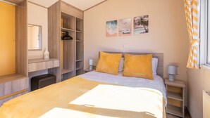 A bedroom with a bed, a desk, and a wardrobe. - 3 Bedroom Caravan-seton Sands (Prestonpans)