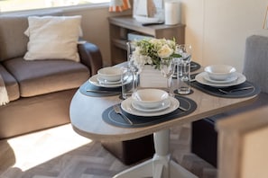 A dining table set with plates, glasses, and a centerpiece.