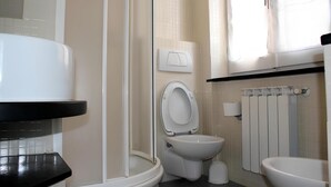 Une salle de bain comprenant des toilettes, un espace douche, une baignoire et un lavabo.