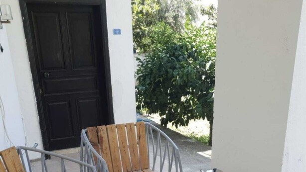 An outdoor dining area with a table set for a meal, surrounded by metal chairs.