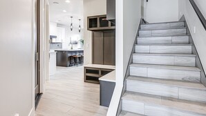 Un interior moderno con una escalera, una zona de cocina y un comedor.