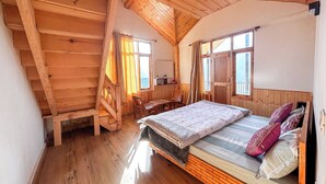 A wooden cabin bedroom with a loft bed, a desk, and a chair. - MonAmis Home (Manali)