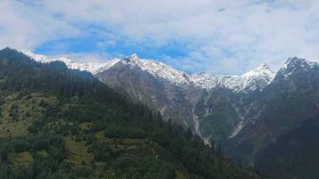 A mountainous landscape with snow-capped peaks and dense forested areas.