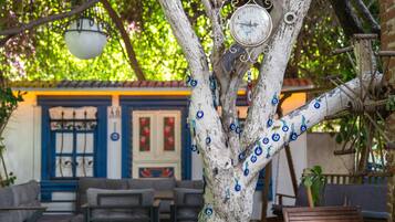A tree with blue ornaments and a clock, a blue door, and a seating area with sofas.