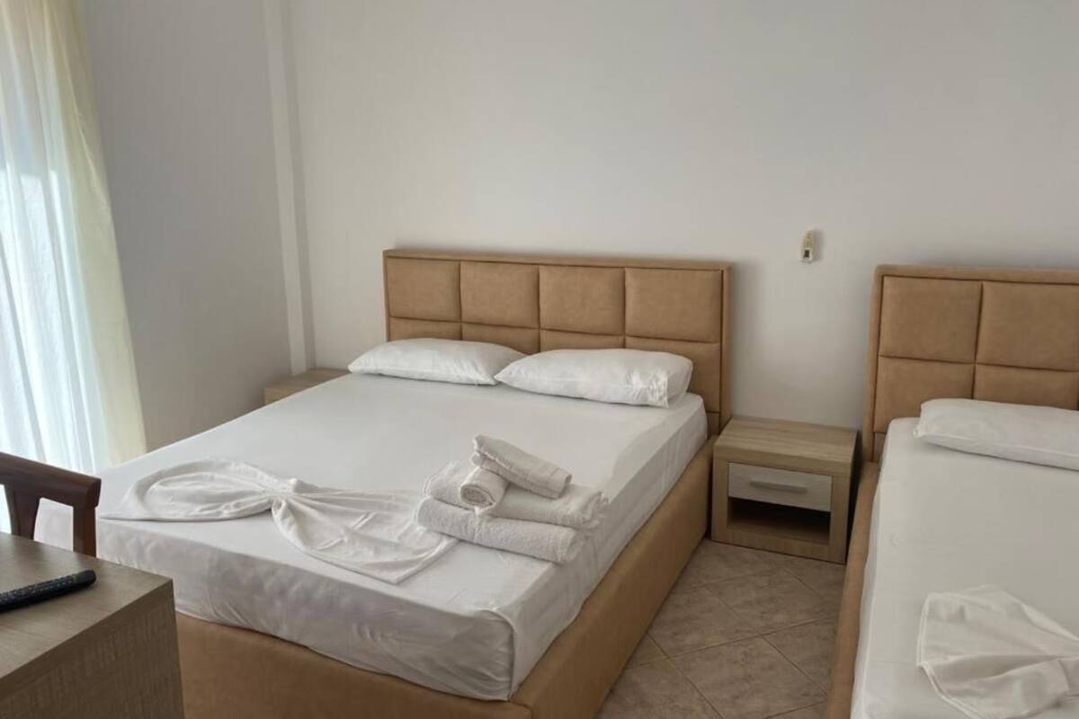 Habitación de hotel con una cama grande, una mesita de noche y una silla.