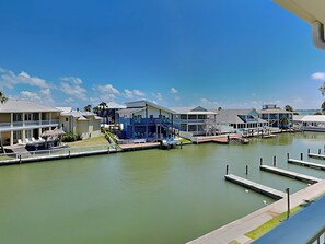 Un puerto deportivo con barcos amarrados, una piscina y un edificio de fachada azul.