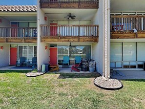 Un bâtiment à deux étages doté d’un balcon, d’un espace extérieur aménagé pour s’asseoir et d’une terrasse couverte.