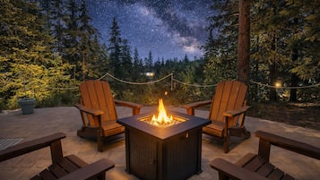 A fire pit with chairs and a view of the night sky.