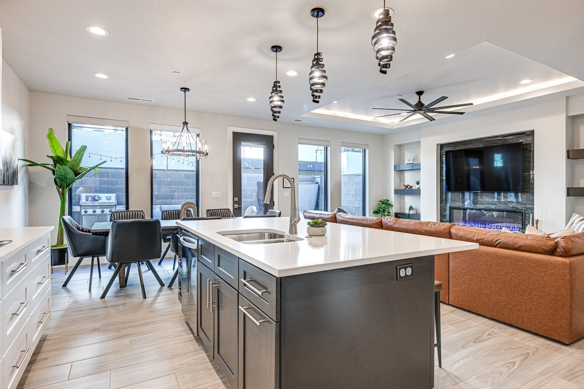 A modern kitchen with a central island, stainless steel appliances, and a built-in oven.