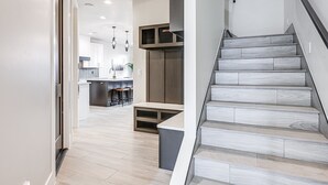 Un intérieur moderne comprenant un escalier, un espace cuisine et un couloir.